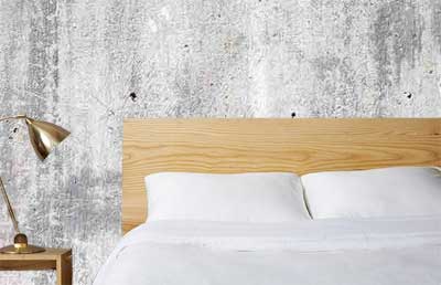 Faux Concrete Wallpaper on Bedroom Wall Behind Bed
